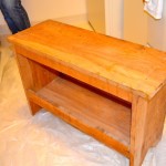 painting a red-orange bench